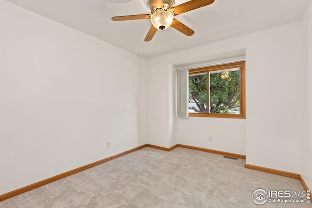 spare room featuring ceiling fan and light colored carpet