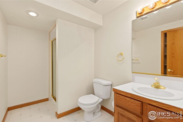 bathroom with vanity, a shower with shower door, and toilet