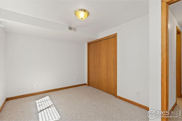 unfurnished bedroom with light carpet and a closet