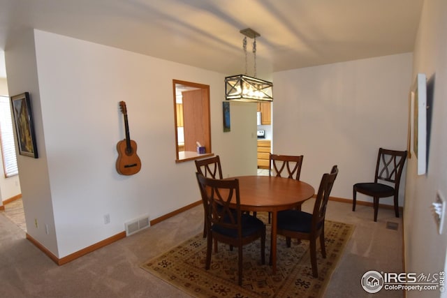 dining area featuring carpet and a chandelier