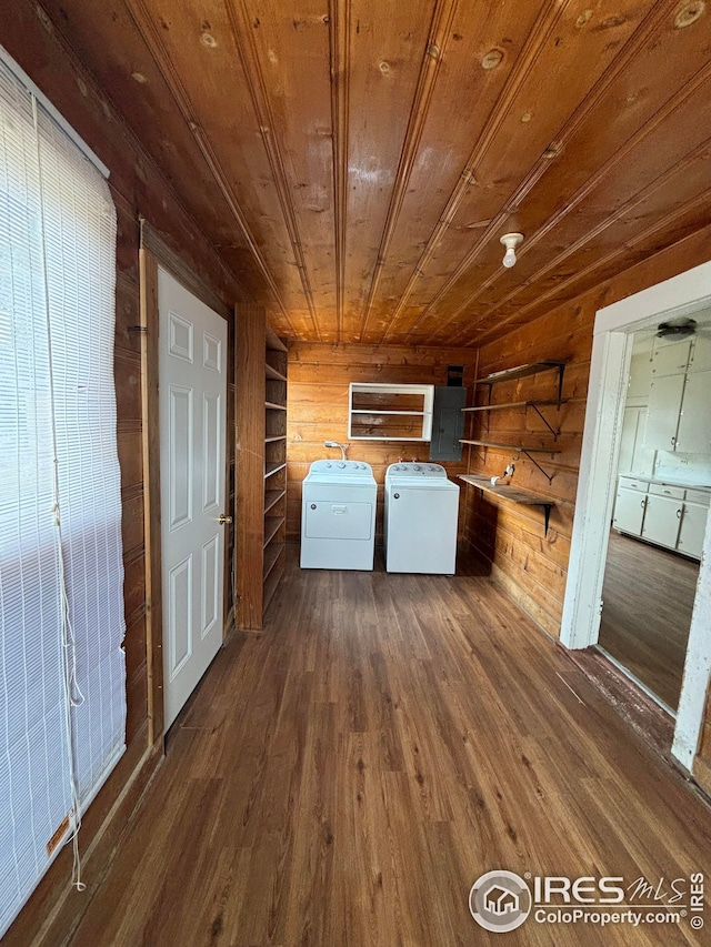 clothes washing area featuring wood ceiling, electric panel, washer and clothes dryer, wooden walls, and dark hardwood / wood-style floors