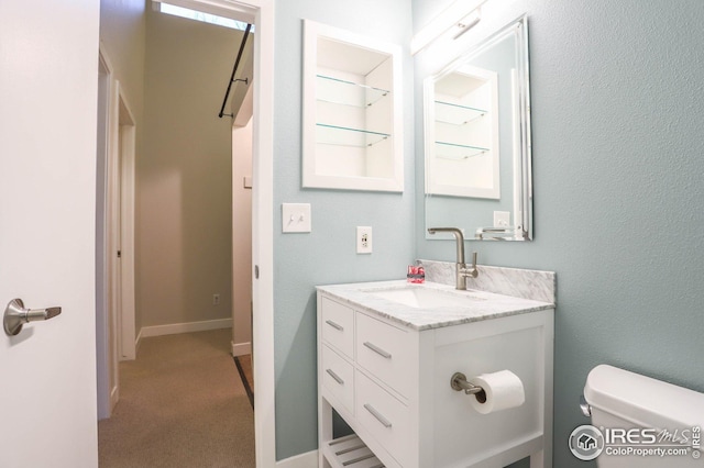 bathroom featuring baseboards, vanity, and toilet