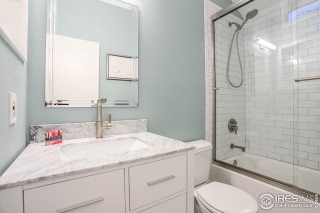 bathroom with enclosed tub / shower combo, vanity, and toilet