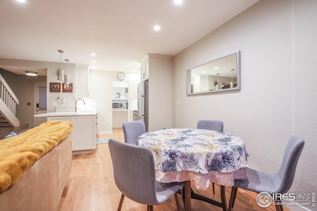 dining room with light wood-style floors, recessed lighting, and stairway