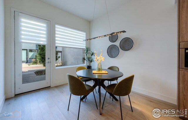 dining area featuring light wood-type flooring and baseboards