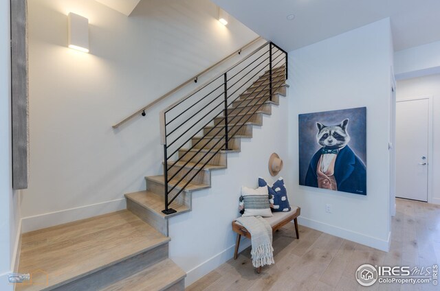 stairway with baseboards and wood finished floors