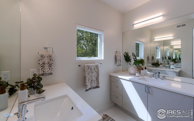 bathroom featuring two vanities, visible vents, and a sink