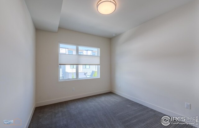carpeted empty room featuring baseboards