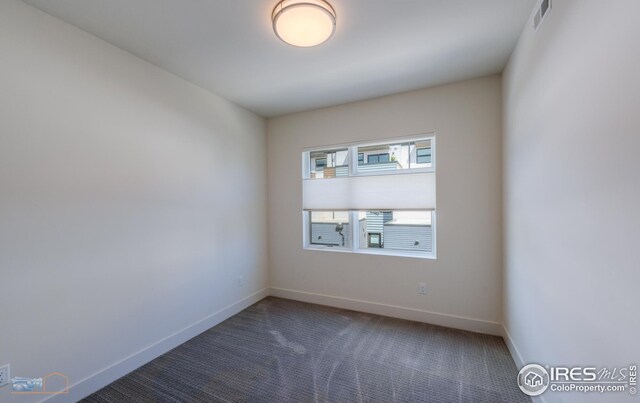carpeted spare room with visible vents and baseboards