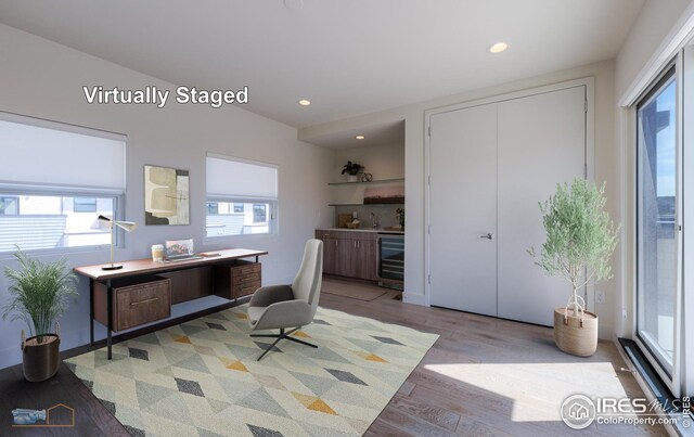 office with beverage cooler, recessed lighting, and wood finished floors
