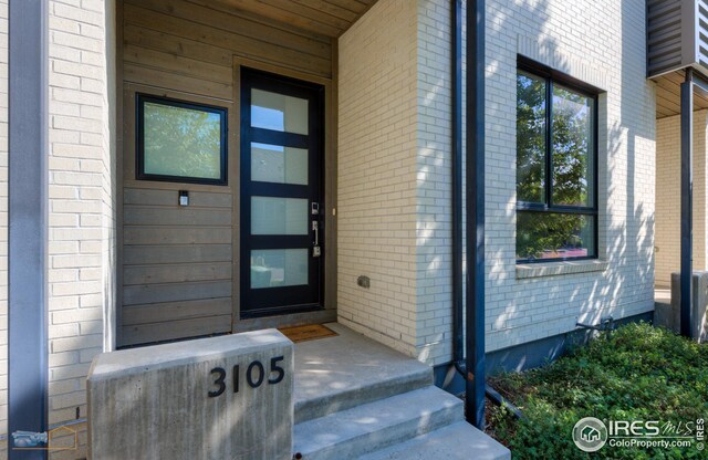 property entrance featuring brick siding