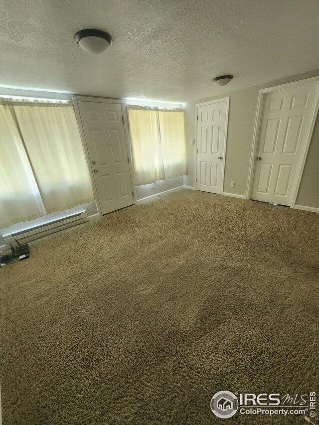 unfurnished bedroom featuring a textured ceiling and carpet