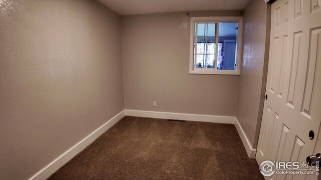 unfurnished bedroom featuring dark colored carpet