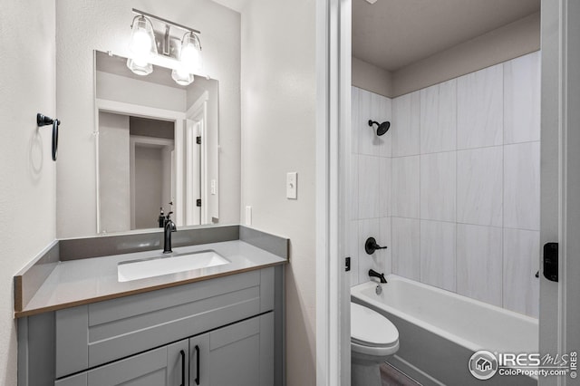 full bathroom featuring tiled shower / bath combo, vanity, and toilet