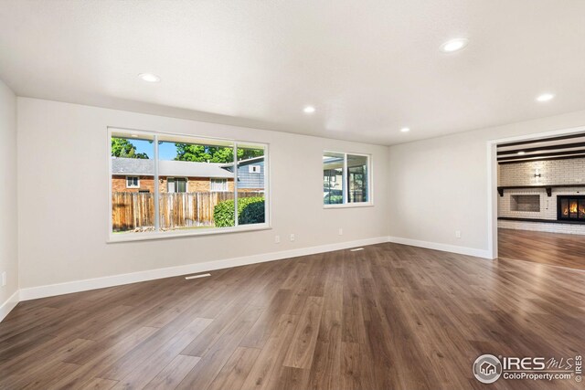 unfurnished living room featuring a fireplace and dark hardwood / wood-style flooring