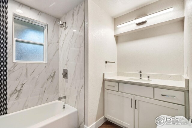 bathroom with vanity and tiled shower / bath combo