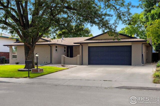 ranch-style home featuring a front lawn and a garage