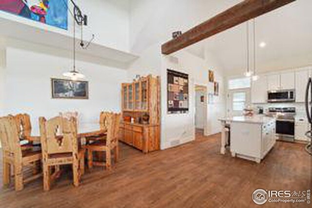 kitchen with appliances with stainless steel finishes, decorative light fixtures, a center island, and white cabinets