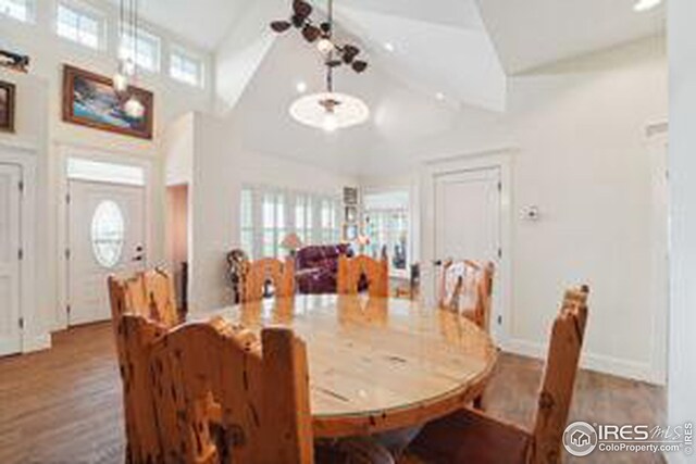 dining room with hardwood / wood-style floors, beamed ceiling, and high vaulted ceiling