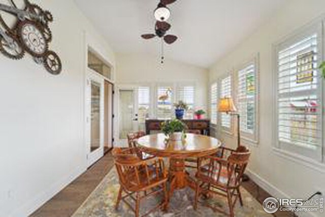 dining area with ceiling fan, vaulted ceiling, and dark hardwood / wood-style flooring