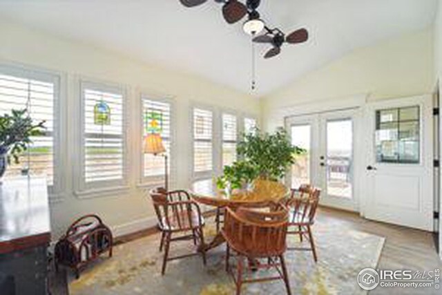 dining space featuring vaulted ceiling, hardwood / wood-style floors, ceiling fan, and french doors