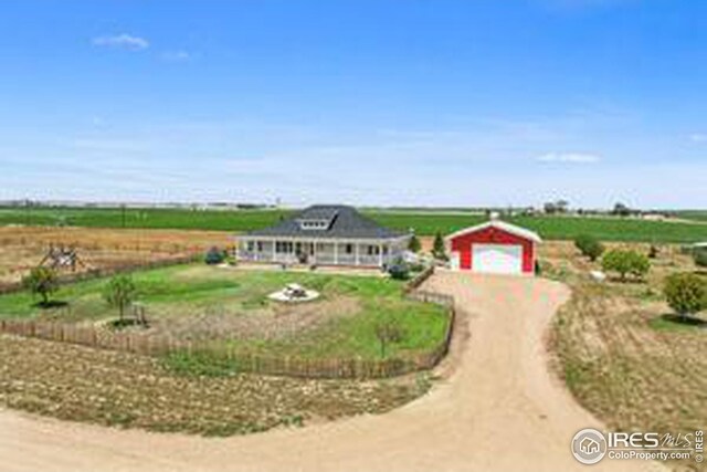 ranch-style home featuring an outdoor structure, a garage, and a rural view