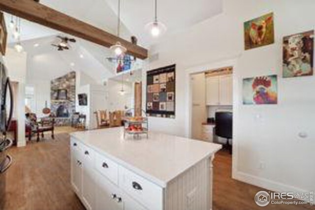 kitchen with pendant lighting, white cabinets, a kitchen island, hardwood / wood-style floors, and ceiling fan