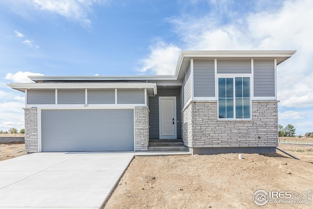 1215 105th Avenue Ct, Greeley, CO 80634 - view of front facade with driveway, stone siding, an attached garage, and entry steps