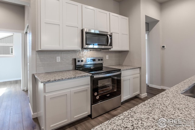 1215 105th Avenue Ct, Greeley, CO 80634 - kitchen featuring white cabinets, stainless steel appliances, backsplash, and dark wood finished floors