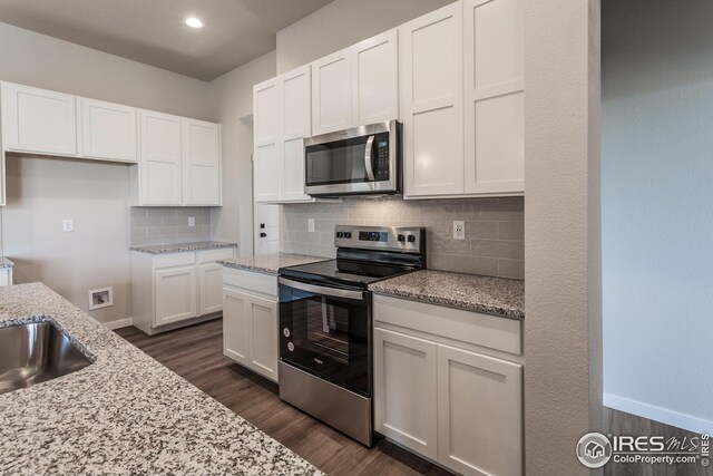 1215 105th Avenue Ct, Greeley, CO 80634 - kitchen featuring backsplash, light stone countertops, stainless steel appliances, white cabinets, and dark wood-style flooring