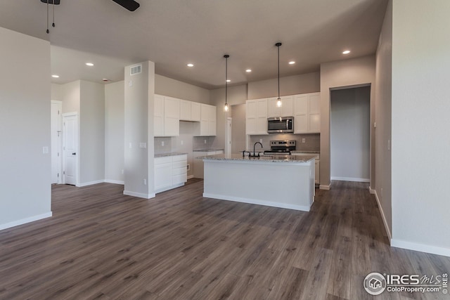 1215 105th Avenue Ct, Greeley, CO 80634 - kitchen featuring dark wood-style floors, white cabinetry, decorative backsplash, and appliances with stainless steel finishes