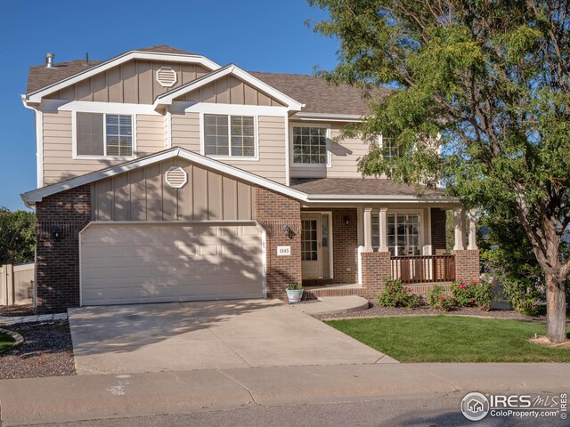 view of front of home featuring brick siding, covered porch, board and batten siding, and driveway