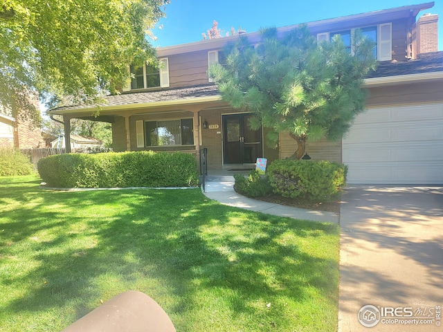 view of front of home with covered porch, a garage, and a front yard