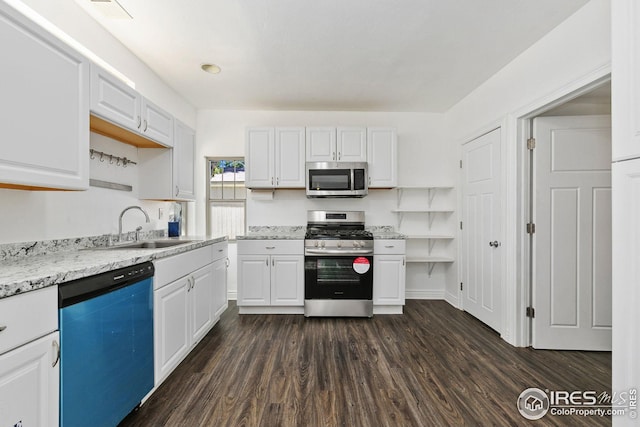 kitchen with sink, appliances with stainless steel finishes, dark hardwood / wood-style floors, light stone countertops, and white cabinets