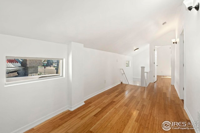 additional living space with lofted ceiling and light hardwood / wood-style flooring