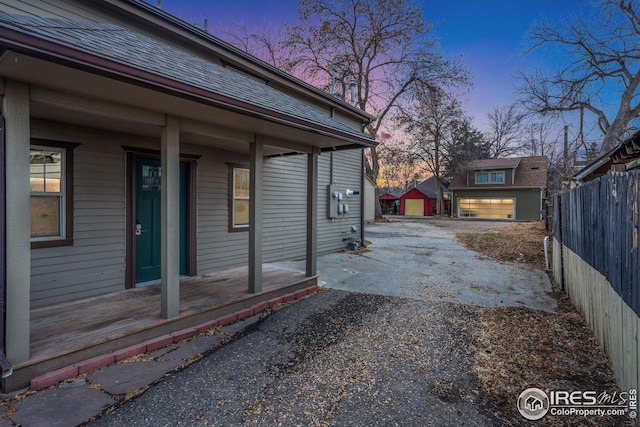 property exterior at dusk with a garage and an outdoor structure