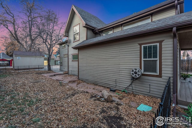 property exterior at dusk with a storage shed