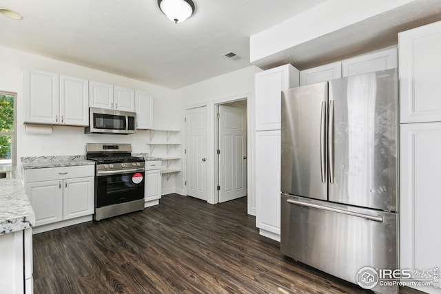 kitchen featuring white cabinetry, stainless steel appliances, dark hardwood / wood-style floors, and light stone countertops