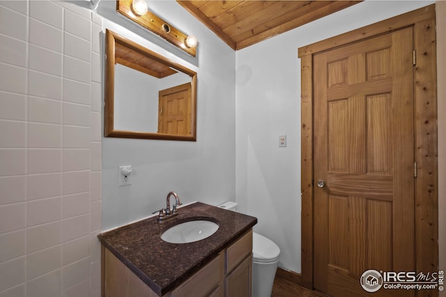 bathroom featuring toilet, wood ceiling, and vanity