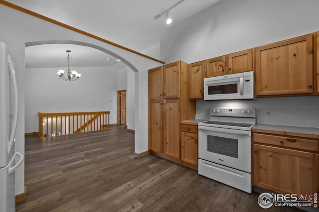 kitchen featuring light countertops, arched walkways, white appliances, and dark wood-type flooring