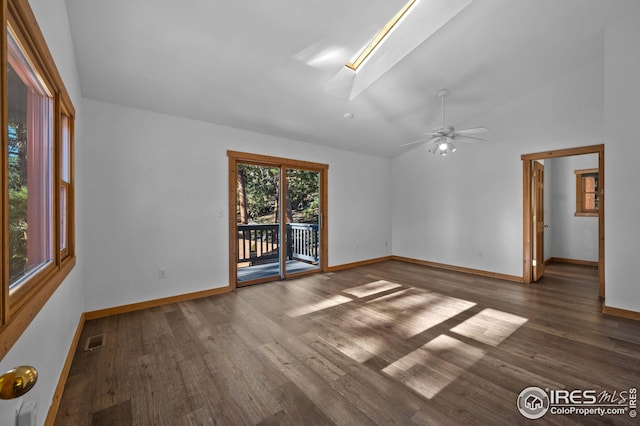 spare room featuring baseboards, lofted ceiling with skylight, wood finished floors, and visible vents