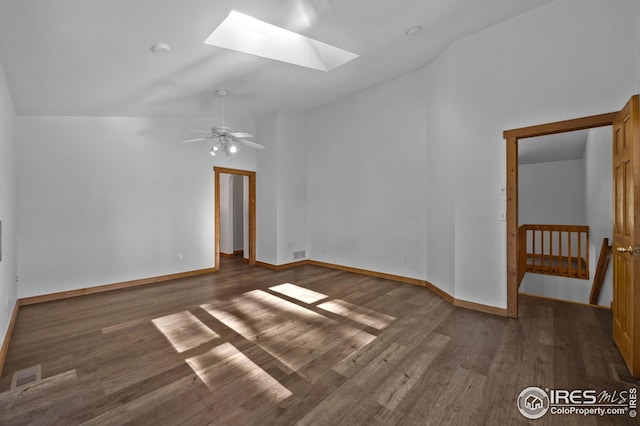 unfurnished room featuring visible vents, baseboards, wood finished floors, and vaulted ceiling with skylight