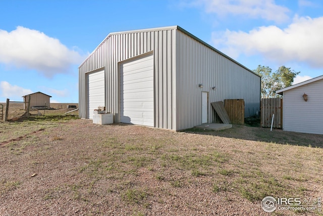 view of outdoor structure with a garage and a lawn