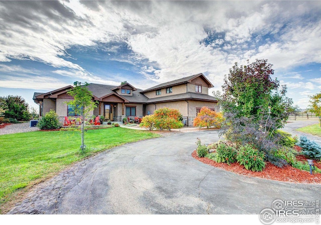 view of front of house featuring aphalt driveway and a front yard