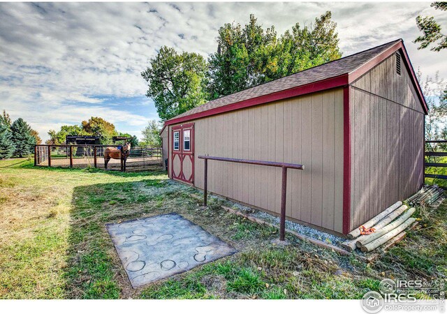 view of outbuilding with fence and an outdoor structure