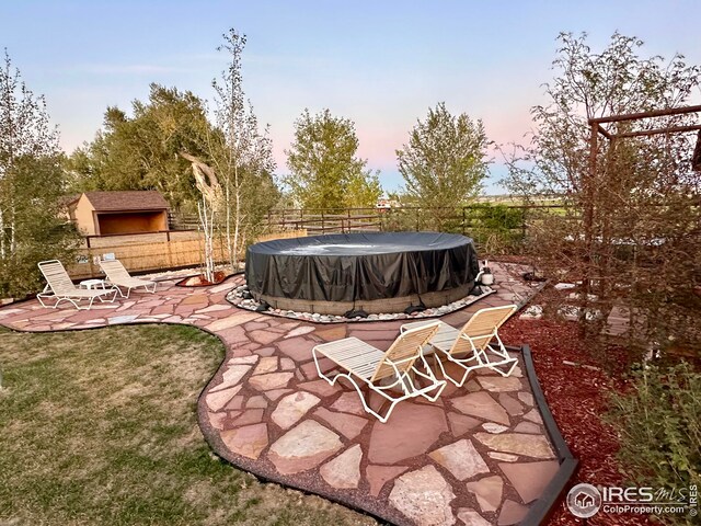 view of pool featuring a yard, a patio area, a covered pool, and fence