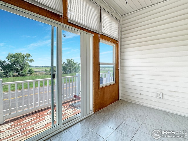 entryway with tile patterned floors and wooden walls