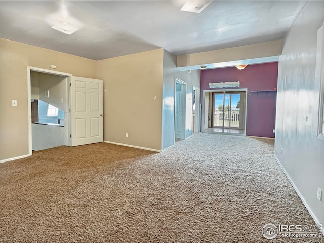 carpeted spare room featuring baseboards