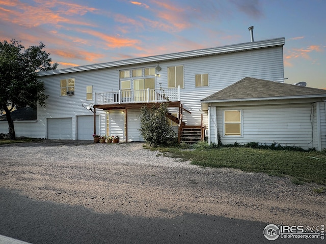 view of front facade featuring stairs, a shingled roof, an attached garage, and driveway