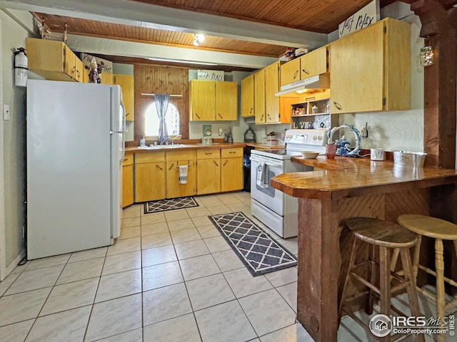 kitchen with light tile patterned floors, wooden ceiling, a peninsula, under cabinet range hood, and white appliances